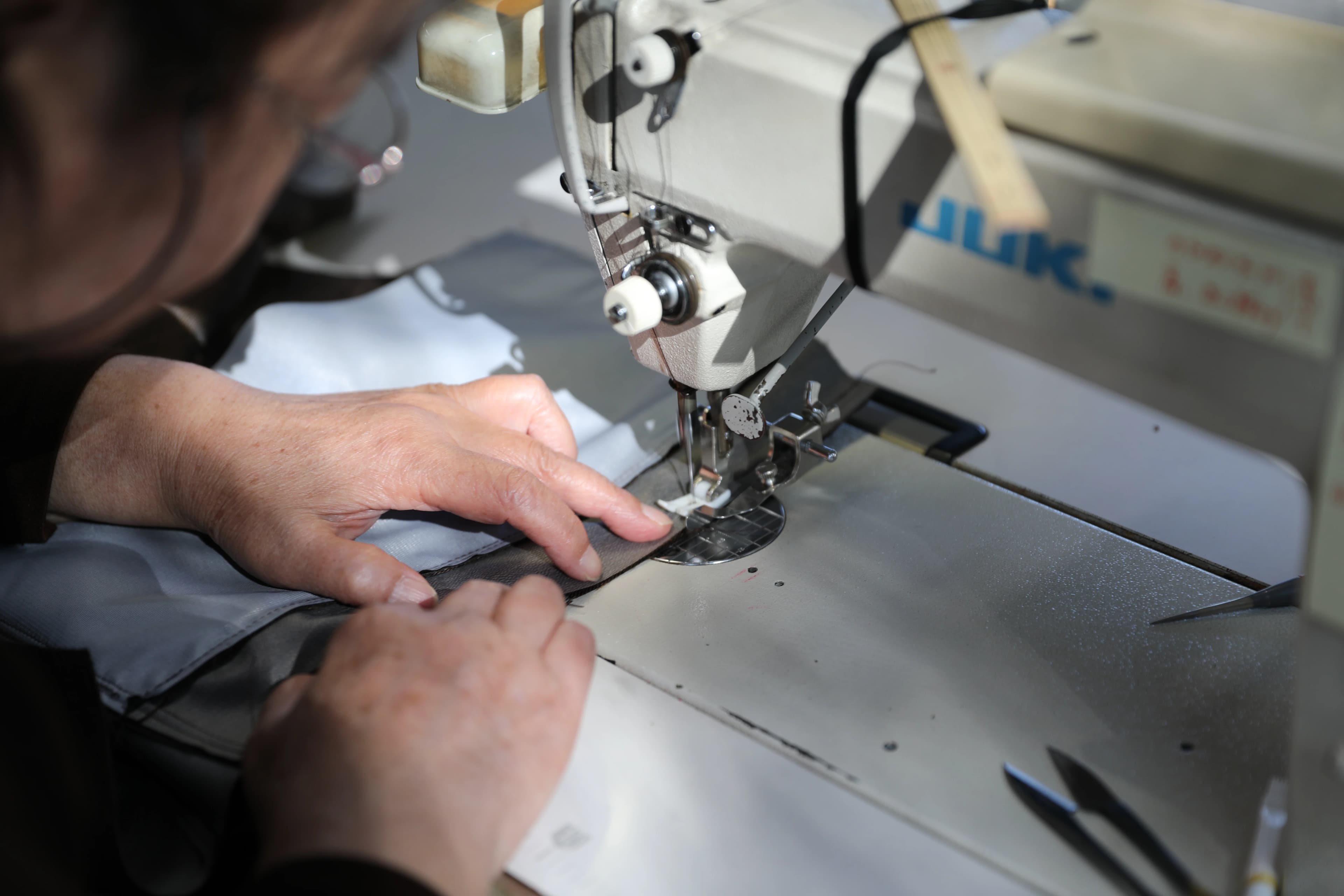 ミシンで縫製作業を行う職人の手元